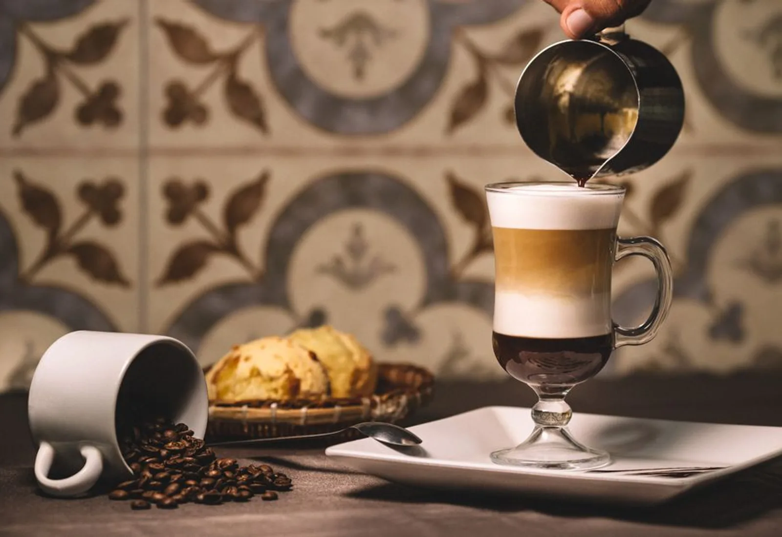 Espresso being poured over gelato in a tall glass