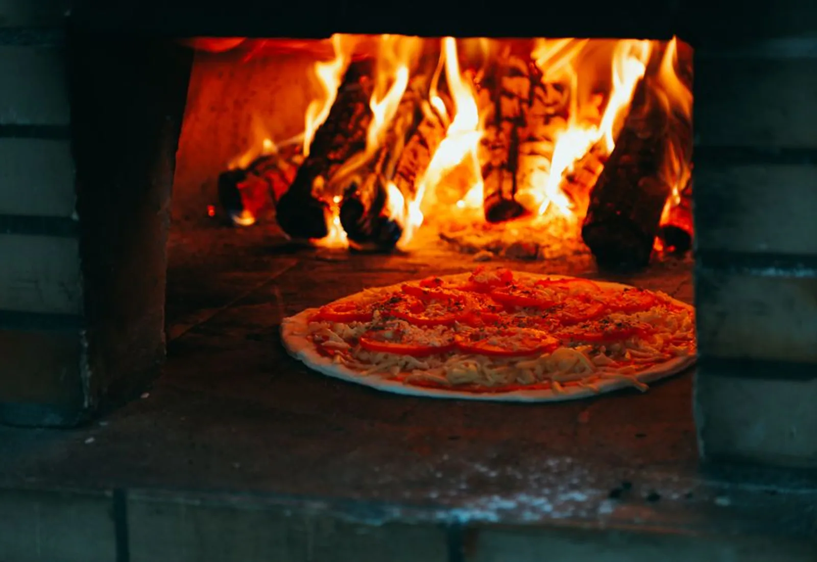 A spicy soppressata pizza just out of the flames of the brick oven