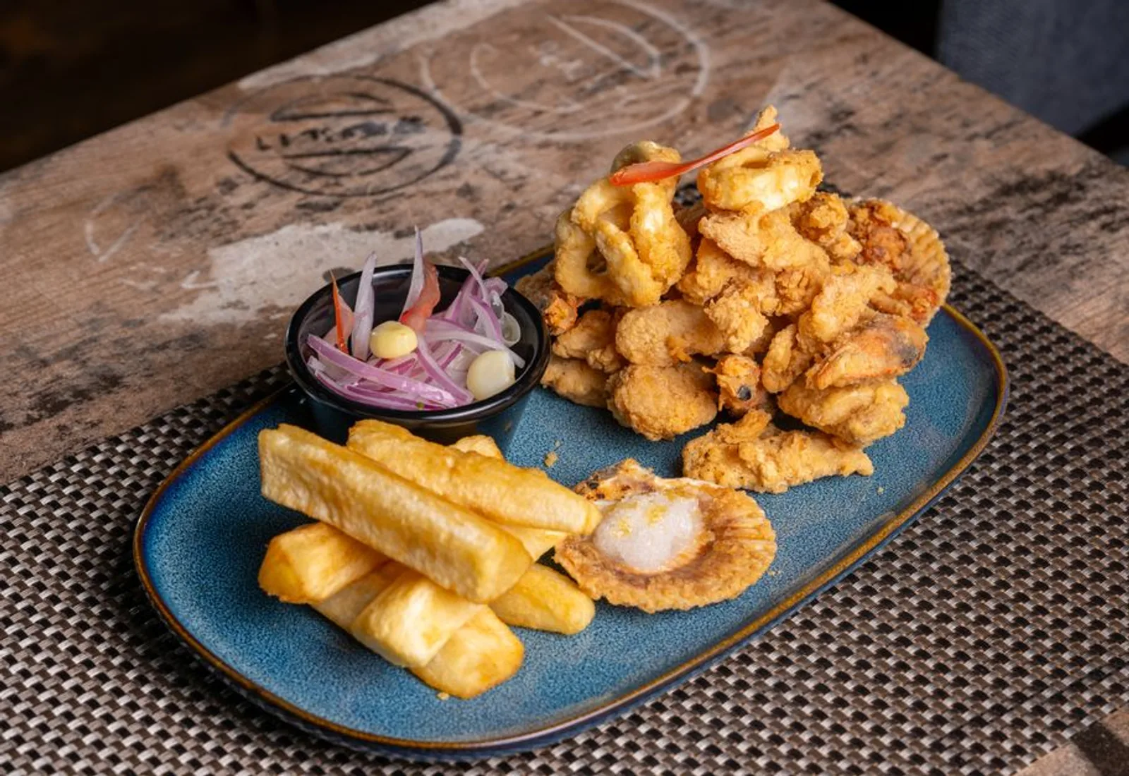 Golden fried calamari and shrimp on a slate board with marinara